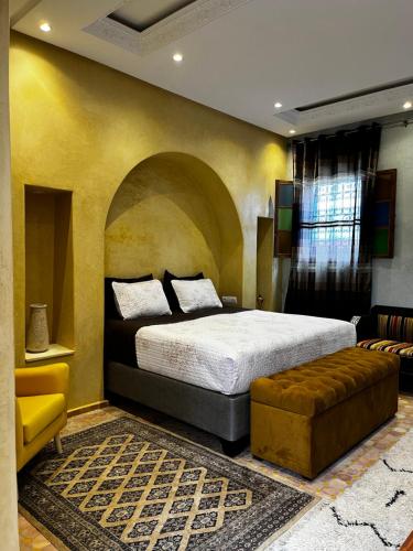a bedroom with a king sized bed and a couch at Casa Indigo in Rabat