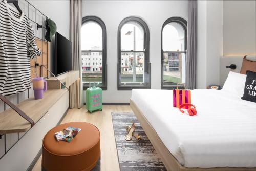 a bedroom with a large white bed and windows at Moxy Cork in Cork