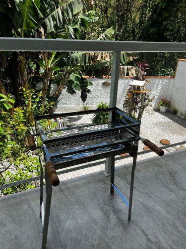 a glass bench sitting on top of a balcony at Casa com banheira in Governador Celso Ramos