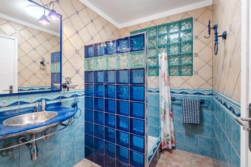 a blue tiled bathroom with a sink and a shower at Lovely apartment in Callao Salvaje in Callao Salvaje