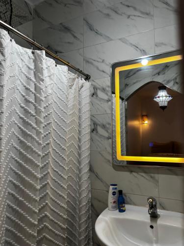 a bathroom with a white shower curtain and a sink at Casa Indigo in Rabat