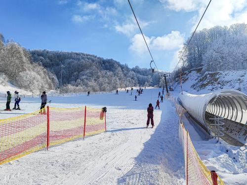 a group of people on a ski lift in the snow at Guesthouse Junior in Kopaonik