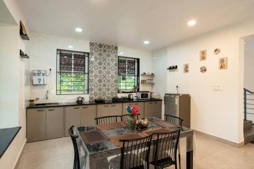 a kitchen with a table and chairs in a kitchen at A spacious 4bhk villa with a pool in Bardez