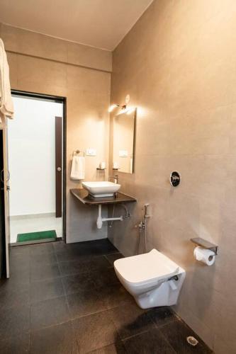a bathroom with a toilet and a sink at A spacious 4bhk villa with a pool in Bardez
