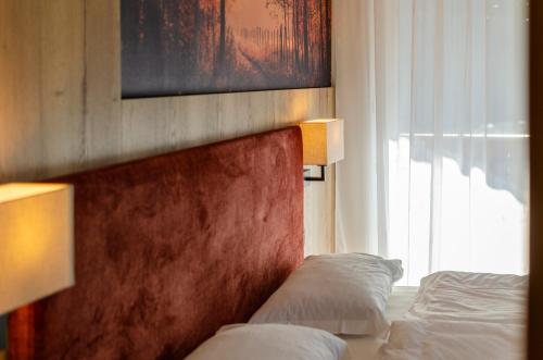 a hotel room with two beds and a window at Villa Gemmy in Pozza di Fassa