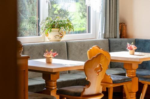 a living room with two tables and a couch at Villa Gemmy in Pozza di Fassa