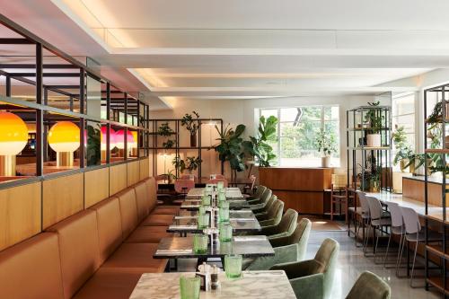 a row of tables in a restaurant with plants at Meliá White House Hotel Apartments in London