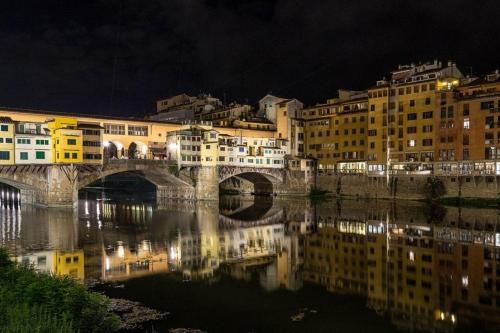 a bridge over a river in a city at night at A'Loro B&B in Terranuova Bracciolini