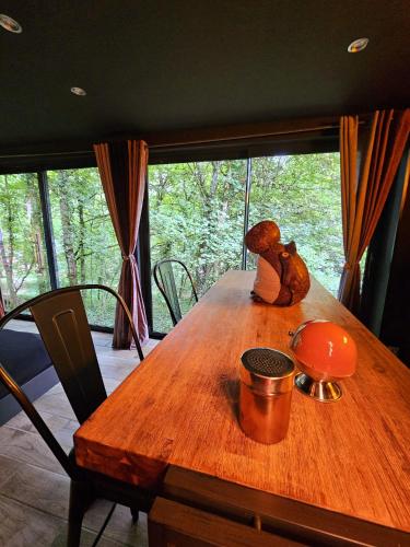 un ours en peluche assis au-dessus d'une table en bois dans l'établissement La Cabane Enchanteresse, à Illoud