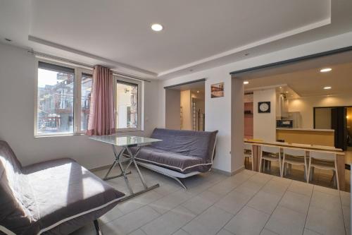 un salon avec un canapé et une table dans l'établissement Marmotte rdc, à Les Deux Alpes