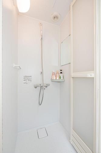 a white bathroom with a shower with a glass door at sunrise 2 in Tokyo