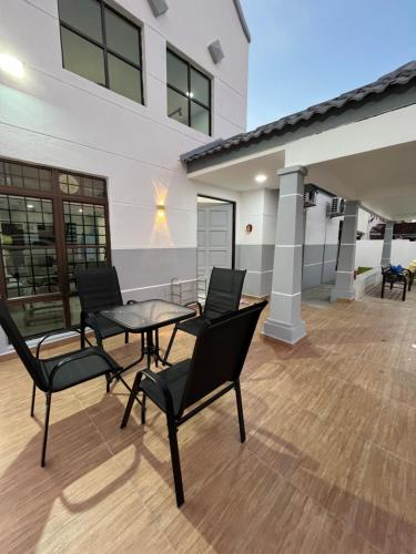 a patio with chairs and a table and a building at 803 Villa AFamosa Villa in Kampong Ulu Pegoh