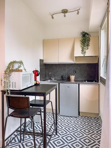 - une cuisine avec une table et un four micro-ondes dans l'établissement Splendide studio de Giverny Vernon Paris, à Vernon