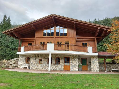 a large wooden house with a balcony on top at Landhaus Stiegler in Untertauern