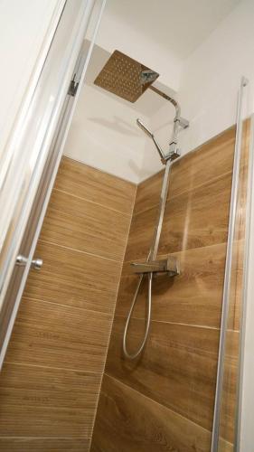 - une douche avec un pommeau de douche sur du parquet dans l'établissement NEW! Wifi, Disney Plus L'Escale des Remparts, à Avignon