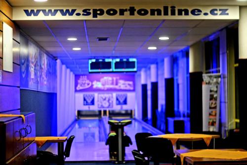a dining room with tables and a bowling alley at Hotel Tennis Club in Prostějov