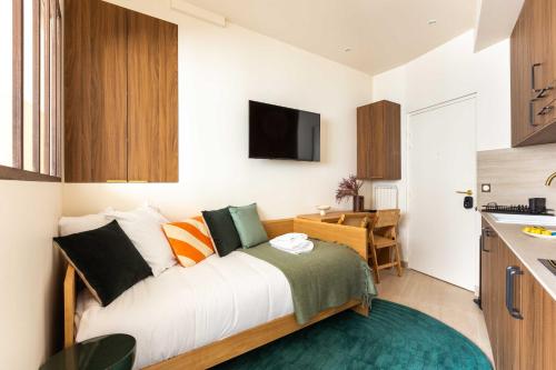 une petite chambre avec un lit et une cuisine dans l'établissement Résidence Port Royal - Jardin du Luxembourg, à Paris
