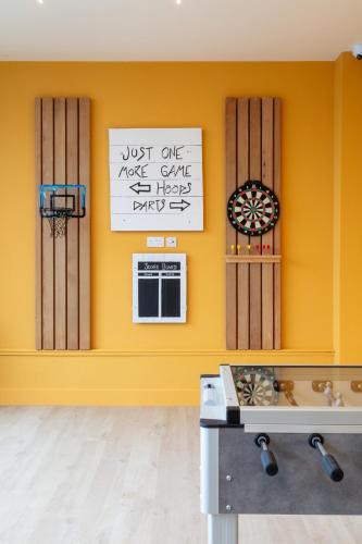a room with a yellow wall with a basketball hoop at SeaSpace in Newquay