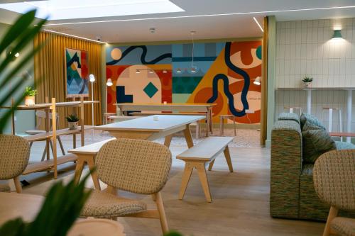 a restaurant with tables and chairs and a colorful wall at SeaSpace in Newquay