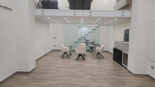 Un comedor con una mesa y sillas blancas. en Pomona Guest House, en Salerno