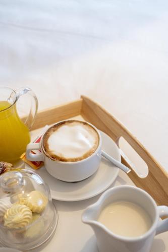 a tray with a cup of coffee and a cup of milk at Palazzo Martinelli in Sorrento
