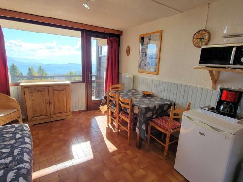une cuisine avec une table et une salle à manger avec vue dans l'établissement Studio cosy 4 pers avec balcon sud, centre station, animaux admis - Saint-Michel-de-Chaillol - FR-1-393-4, à Saint-Michel-de-Chaillol