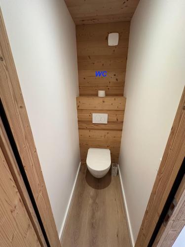 La salle de bains est pourvue de toilettes et d'un mur en bois. dans l'établissement Les loups blancs, à Courchevel