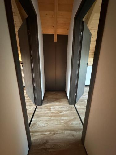 a hallway with two open doors in a room at Sielskie Chatki - domki Twardorzeczka Lipowa in Plebańska