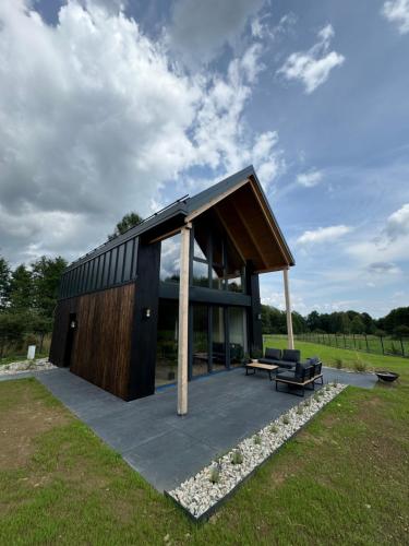 a modern house with a large roof at Sielskie Chatki - domki Twardorzeczka Lipowa in Plebańska