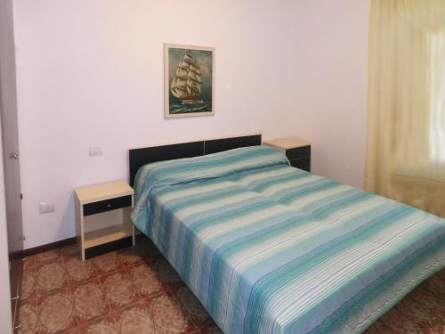 a small bedroom with a bed and a night stand at Occidente in Lignano Sabbiadoro