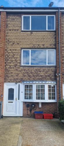 a brick building with a white door and windows at Cozy flat & Lovely garden, High Speed WiFi in Cranford