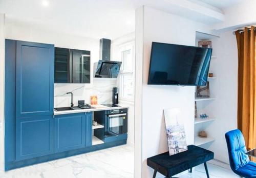 Il comprend un salon doté d'une armoire bleue et d'une télévision. dans l'établissement 2P Moderne proche Promenade des Anglais, aperçu mer, à Nice