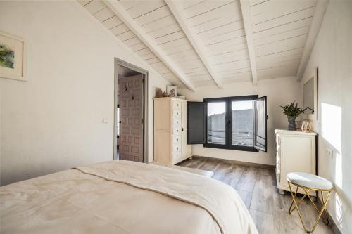 a white bedroom with a bed and a window at Finca Gran Cerros in Alora