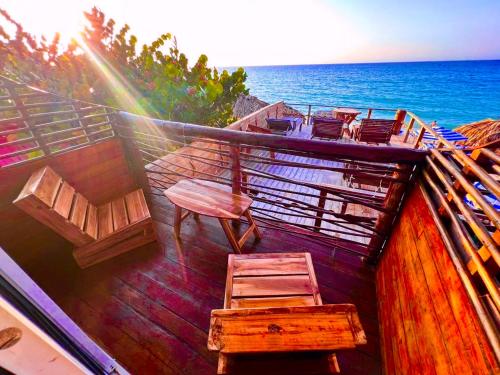 a balcony with chairs and the ocean in the background at Casa MAGGY BARU BEACH in Playa Blanca