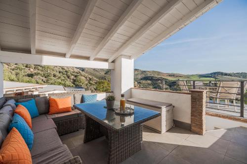 a patio with a couch and a table on a balcony at Finca Gran Cerros in Alora