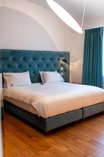 a bedroom with a large bed with a blue headboard at Palazzo Martinelli in Sorrento