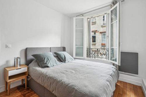 une chambre avec un grand lit et une fenêtre dans l'établissement Élégant Tour Eiffel, à Paris