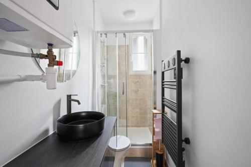 La salle de bains est pourvue d'un lavabo noir et d'une douche. dans l'établissement Élégant Tour Eiffel, à Paris