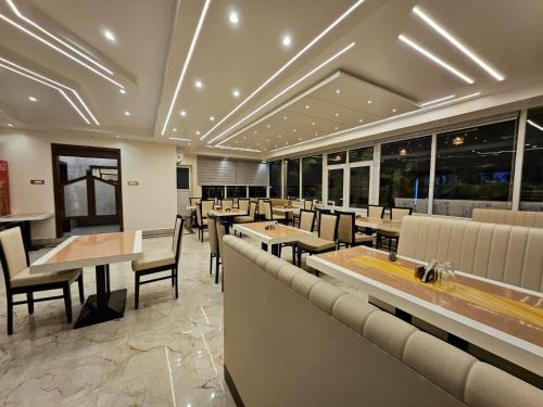德奥加尔HOTEL MAA LAXMI PALACE的有桌椅和窗户的餐厅