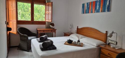 Un dormitorio con una cama y una silla y una ventana. en Green Oasis, en Gran Alacant