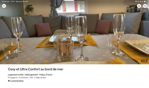 a table with wine glasses on top of it at cosy et ultra confort au bord in Fréjus