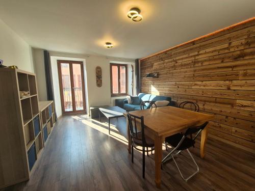 a room with a table and chairs and a wooden wall at 6 GRANDE RUE - Superbe 2 pièces hyper centre in Bourg-Saint-Maurice
