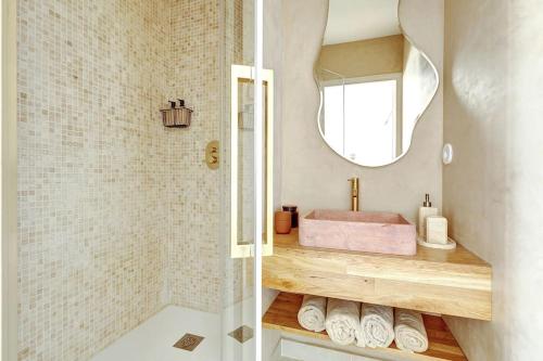 une salle de bain avec un lavabo et une douche avec un miroir dans l'établissement La vue du Marais, à Paris