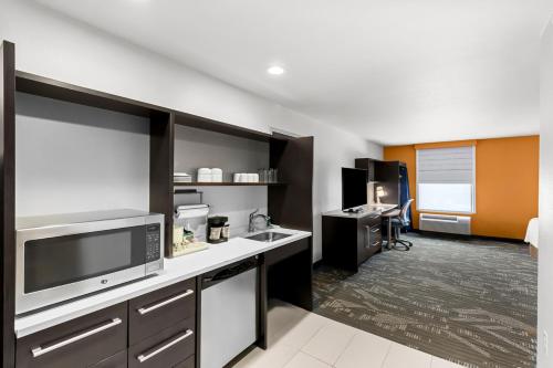 a room with a kitchen with a sink and a microwave at Home2 Suites by Hilton Irving/DFW Airport North in Irving