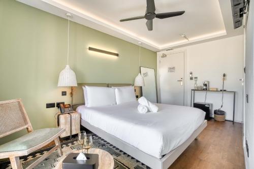 a bedroom with a large white bed with a ceiling fan at The Bear and Ween in St Julian's