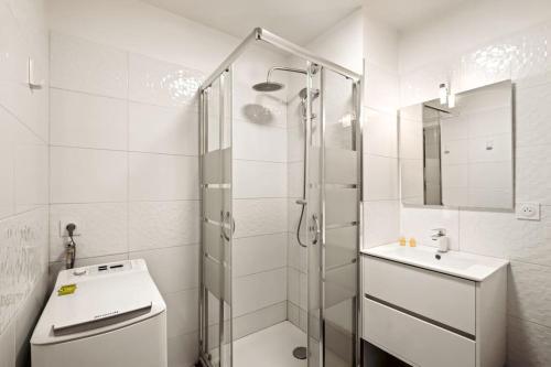 une salle de bain blanche avec une douche et un lavabo dans l'établissement apartment ideal location for Lyon Center, à Villeurbanne