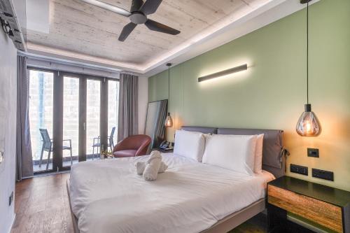 a bedroom with a white bed with a ceiling fan at The Bear and Ween in St Julian's