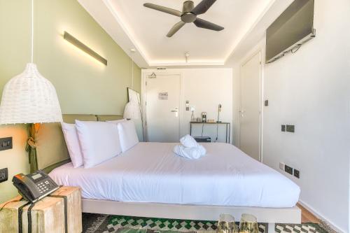 a bedroom with a white bed with a ceiling fan at The Bear and Ween in St Julian's