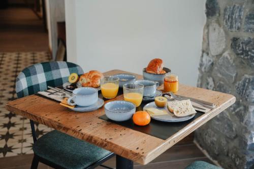 a wooden table with breakfast foods and orange juice on it at Hostellerie du Petit Saint Bernard in Bourg-Saint-Maurice