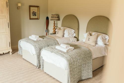 a bedroom with two beds with towels on the seats at Nest Farmhouse in Docking